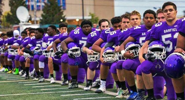 Seattle's Garfield High School football team kneels in protest during the national anthem