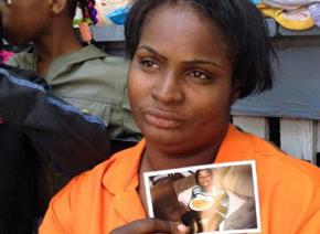 Patricia Larry holds up a photo of her son Darius as neighbors and friends gather in sympathy