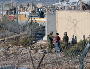 IDF soldiers interrogate a Palestinian youth at a West Bank checkpoint