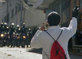 A worker faces off against police in a mass strike under Morales in 2012
