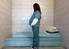 A pregnant woman languishes in a bare prison cell