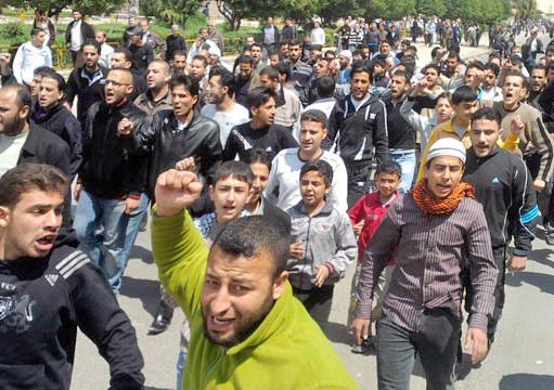 Protesters marching through the streets of the Syrian city of Homs
