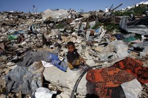 A young boy sits amid the rubble where buildings once stood in Jabalia, a town in the northern Gaza Strip