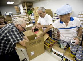 Volunteers pack boxes of donated food for low-income families in Anderson, Calif.