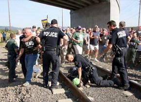Police break up a gathering of ILWU protesters blocking the path of a train near the Port of Longview