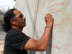 Aaron Dixon, a delegation participant, leaves a message of solidarity on the Israeli apartheid wall