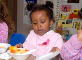 A child eats breakfast at a subsidized day care program for low-income kids