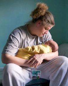 An incarcerated mother holds her infant child inside her prison cell