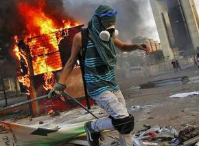 A student demonstrator sets fire to a barricade in Caracas