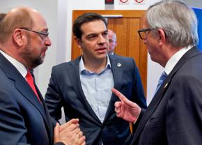 Greek Prime Minister Alexis Tsipras listens to European Commission President Jean-Claude Juncker