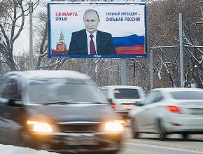 Commuters pass an election billboard on a Moscow highway