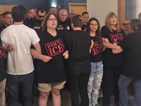 Immigrant rights activists block the entrance to an ICE office in Syracuse